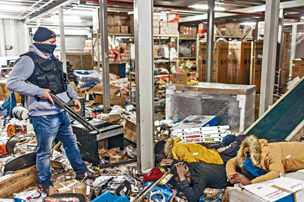 南非沃斯卢鲁斯市一间购物中心内，有抢掠者被保安人员制服，伏在地上。