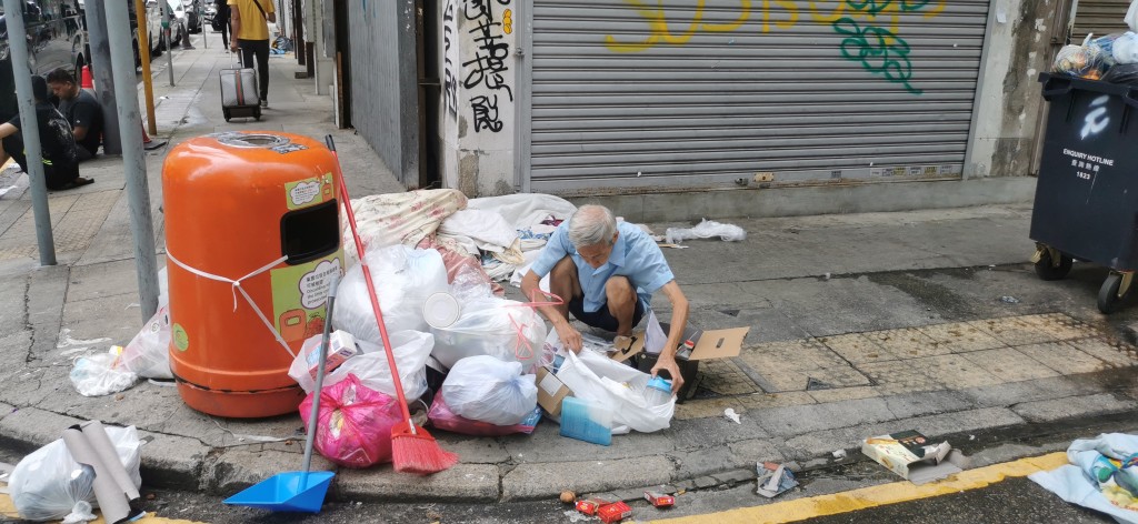 有拾荒者趁垃圾无人清理在垃圾堆中寻宝。（莫家文摄）