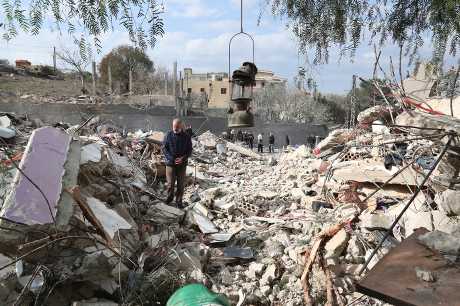  黎巴嫩南部班特吉貝爾鎮一名居民站在周二晚遭以軍空襲摧毀的民房瓦礫堆。美聯社