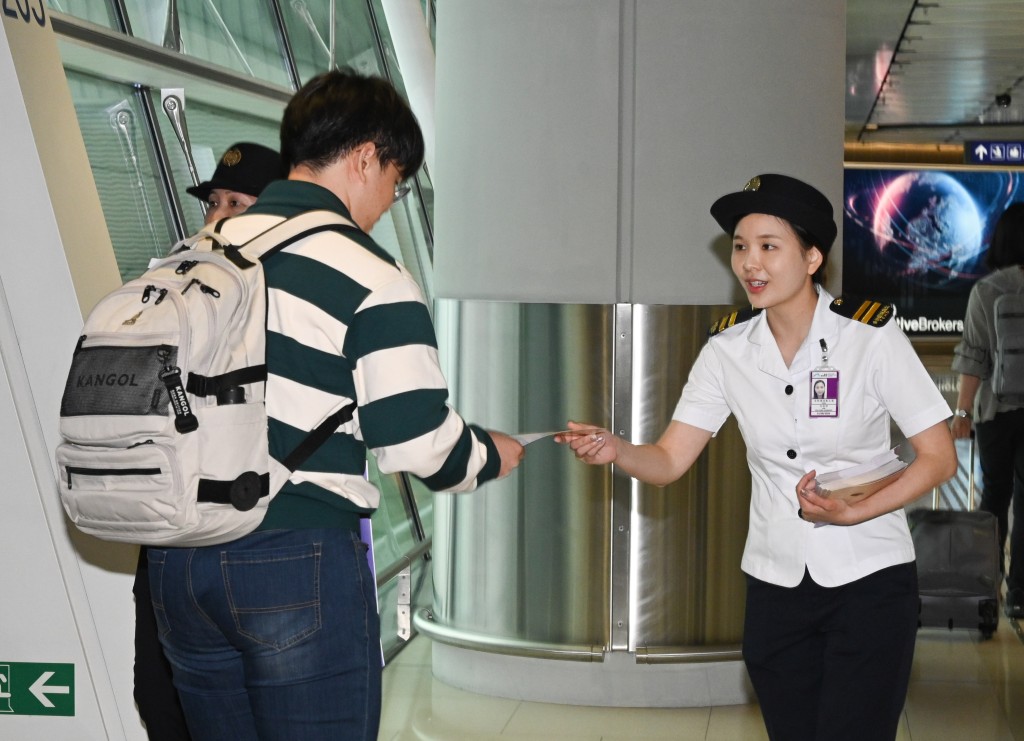 食環署人員在香港國際機場向入境旅客派發宣傳單張。政府新聞處圖片