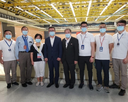 鄧以海(左四)昨應邀到中山紀念公園的火眼實驗室參觀，他向華昇診斷中心董事長胡定旭及一眾內地核酸檢測支援隊成員，了解了實驗室的運作情況。