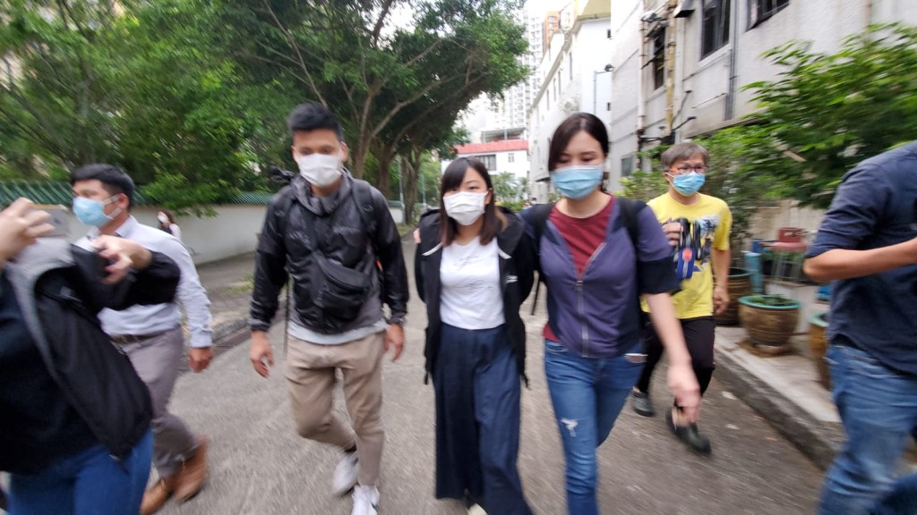何忻諾(中)被押解返住所搜查。