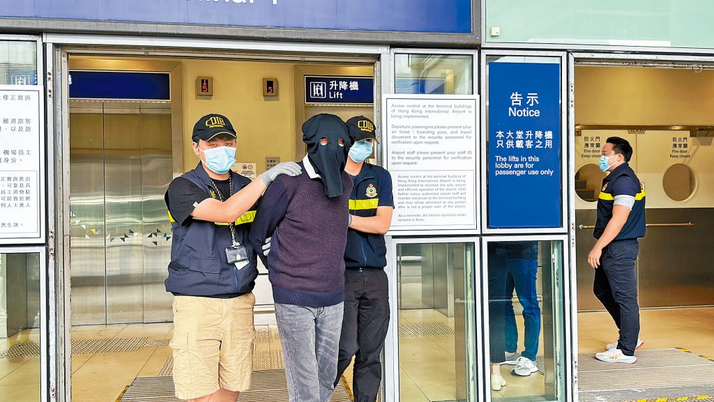海關於機場將涉嫌以書本藏毒旅客帶走。 
