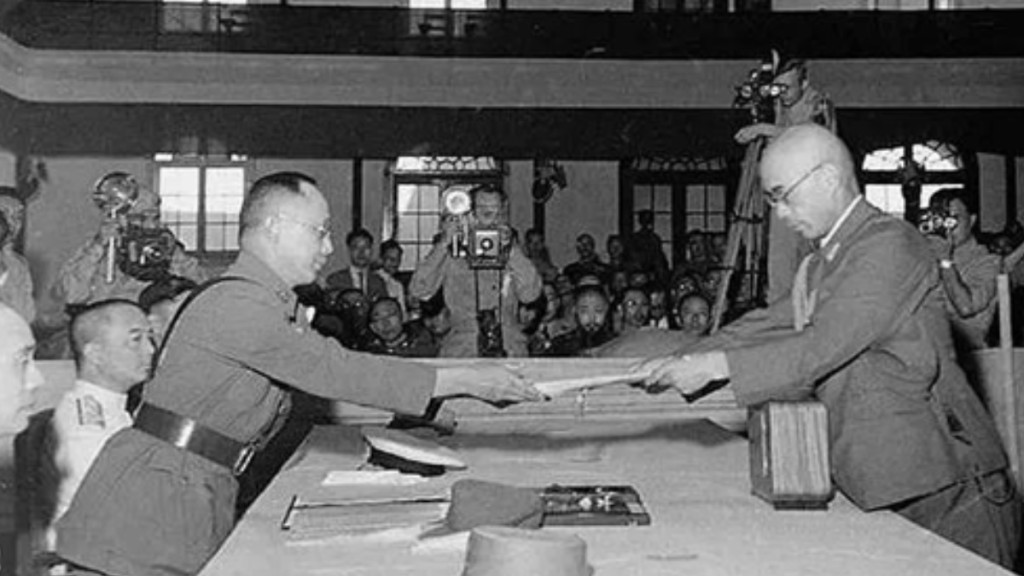 1945年9月9日，侵華日軍最高指揮官岡村寧次（右）在南京向中國陸軍總司令何應欽遞交投降書。人民網