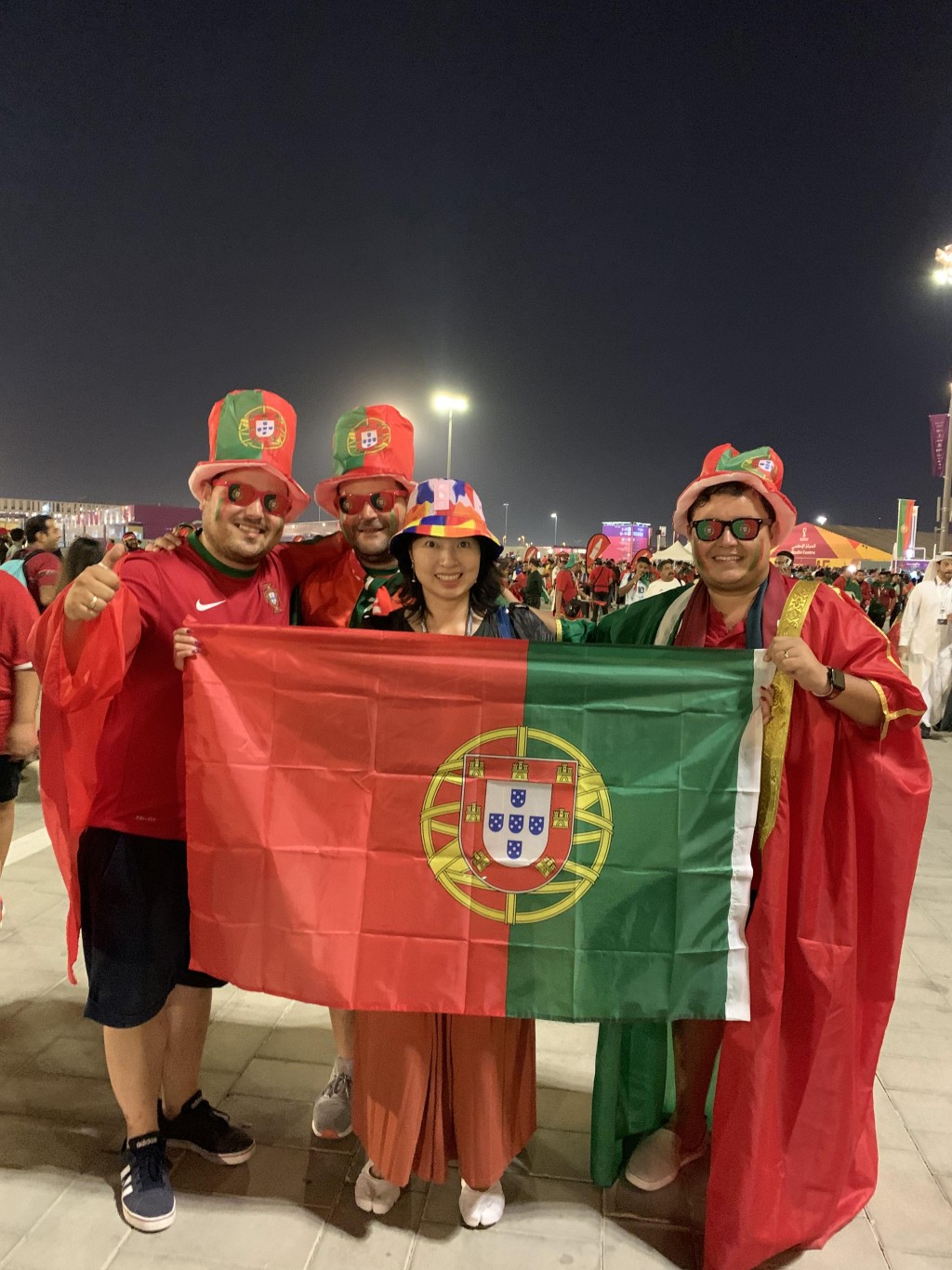 葡萄牙球迷在外形像金饭碗的球场外合照。