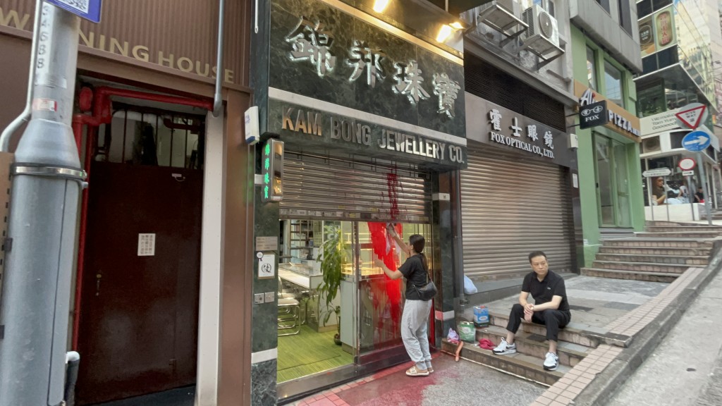 珠寶店負責人及職員清理油漆。