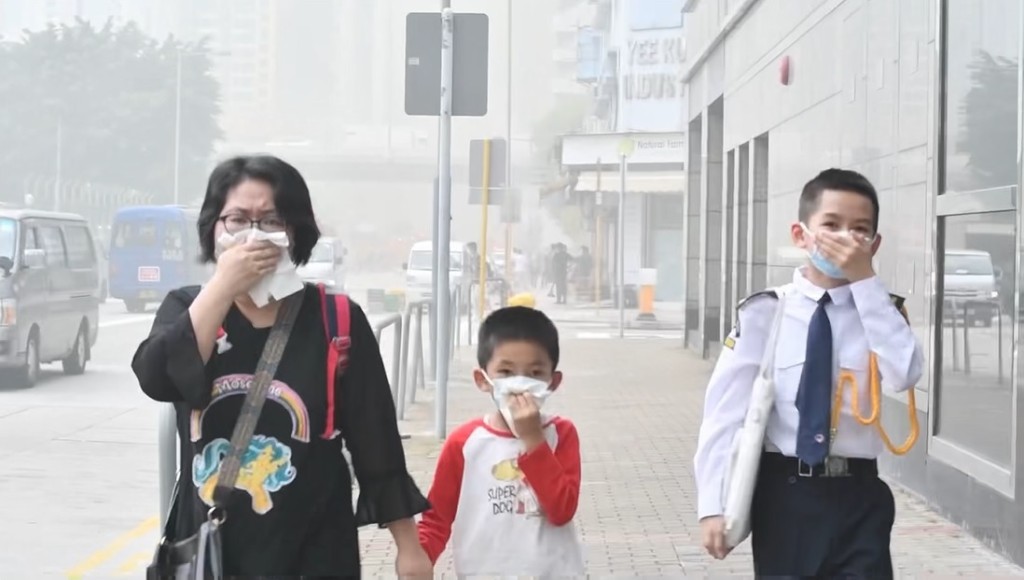 空氣中充斥燶味，家長接送子女放學時要用紙巾掩鼻而行。(盧江球攝)