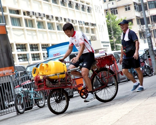 阿寶試踩雄哥的單車，單是載兩罐石油氣都要時間掌握平衡。