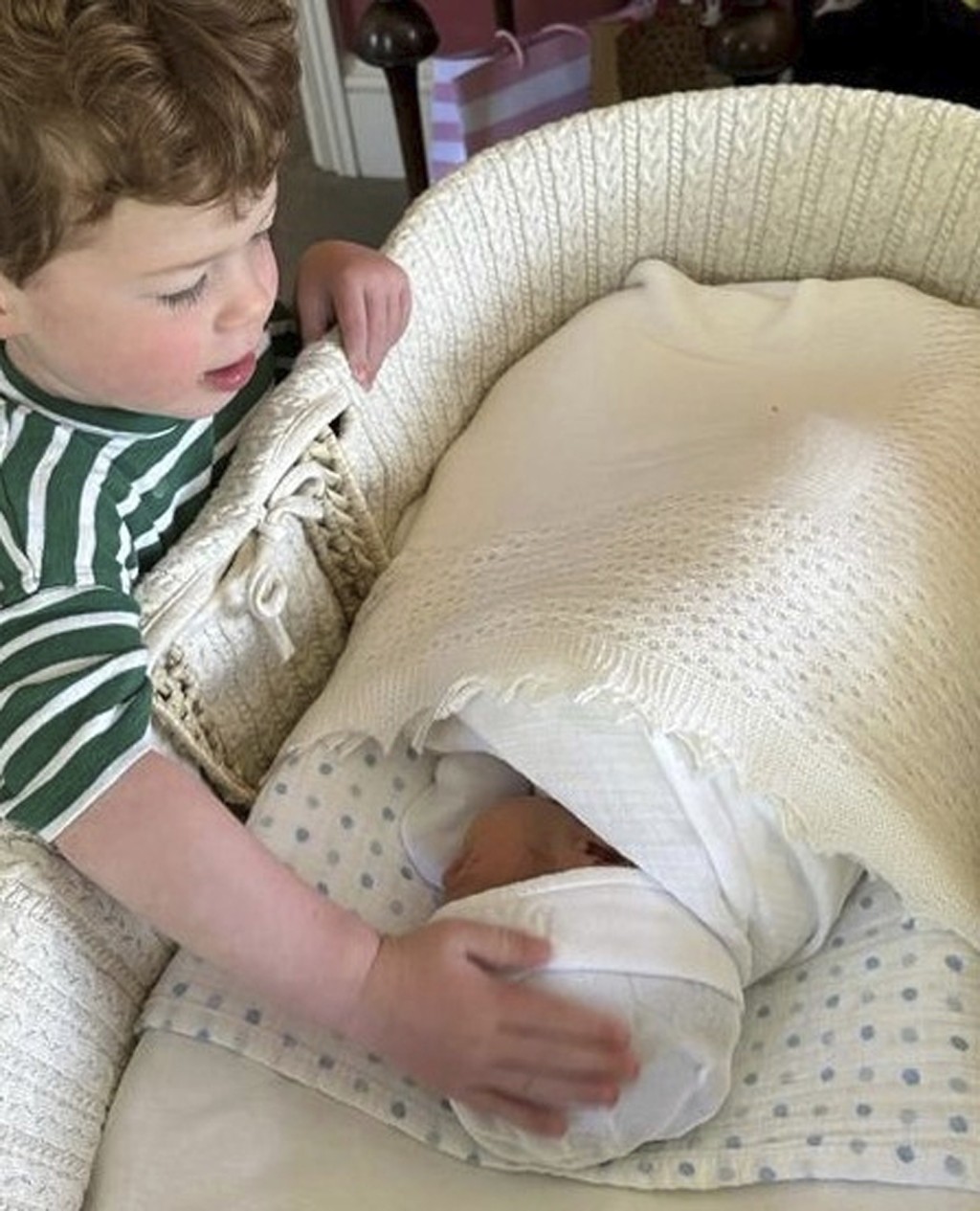 哥哥奥古斯特站在婴儿床前摸住弟弟的头。美联社