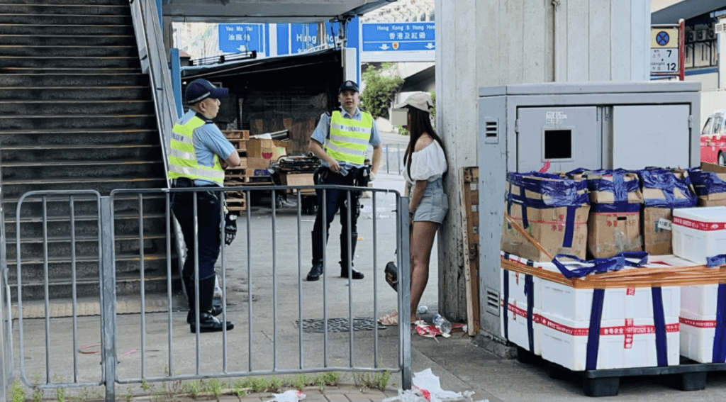 女乘客戴帽和穿热裤，站在路旁协助警员调查。蔡楚辉摄