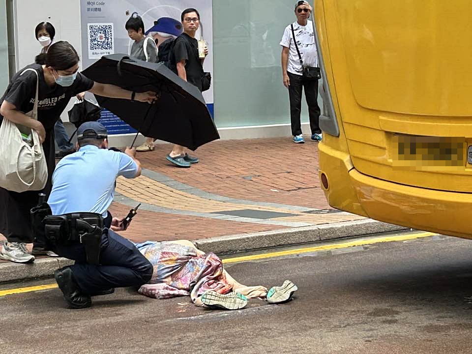 警员及一名热心女途人协助伤者。fb：John Ng