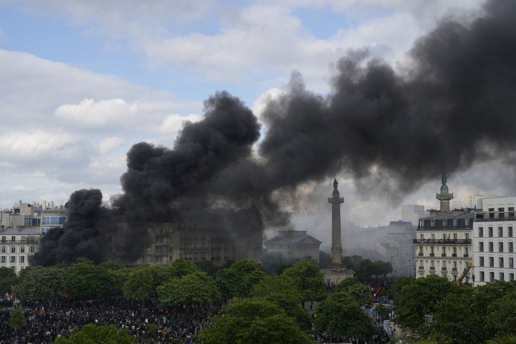 巴黎示威活動中，年輕人放火後，民族廣場上冒出濃煙。AP