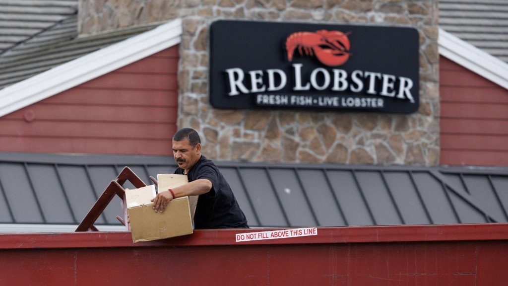一名男子從加州聖地牙哥已關閉「紅龍蝦」分店前的垃圾箱收集物品。 路透社