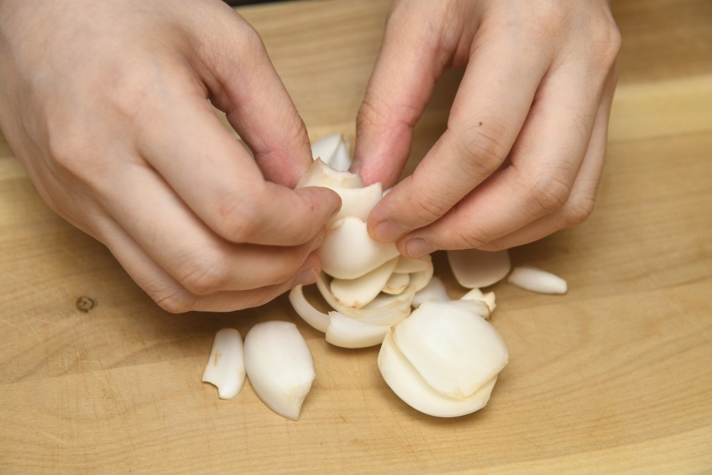 Step 3: 鮮百合除去根部，剝成一瓣瓣洗淨，浸水兩分鐘。 Cut the root from the lily bulb, break up into petals, rinse them and soak them in water for 2 minutes.