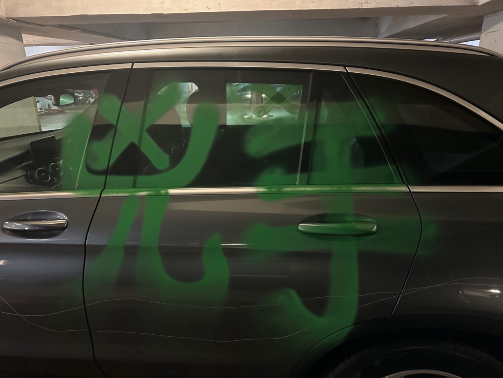 左右两边车身及车尾均被人划花，并以绿色油漆喷上「凶手」两个大字。