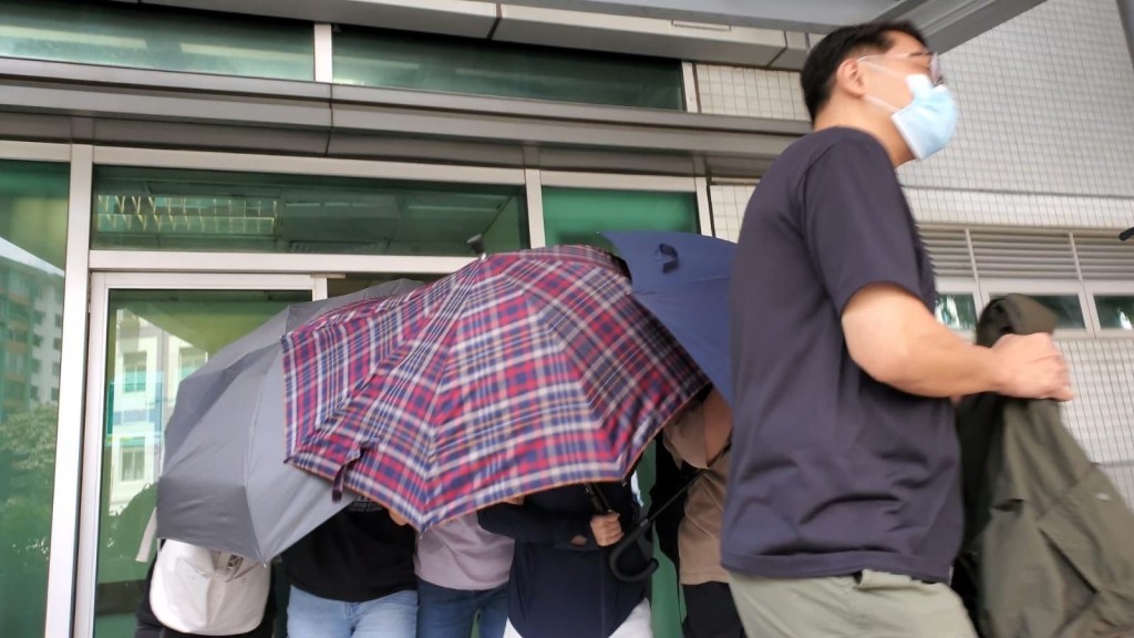 今獲准保釋的被告趙詠茜在親友傘陣下護送離開。