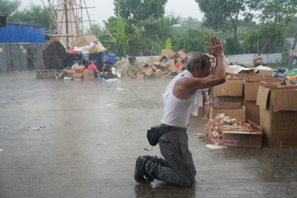  村民在大雨中拜祭祈求平安。 吴艳玲摄