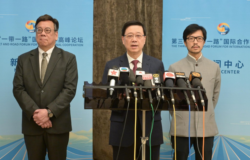 李家超（中）在北京，聯同商務及經濟發展局局長丘應樺（左）和「一帶一路」專員何力治（右）會見傳媒。政府新聞處圖片