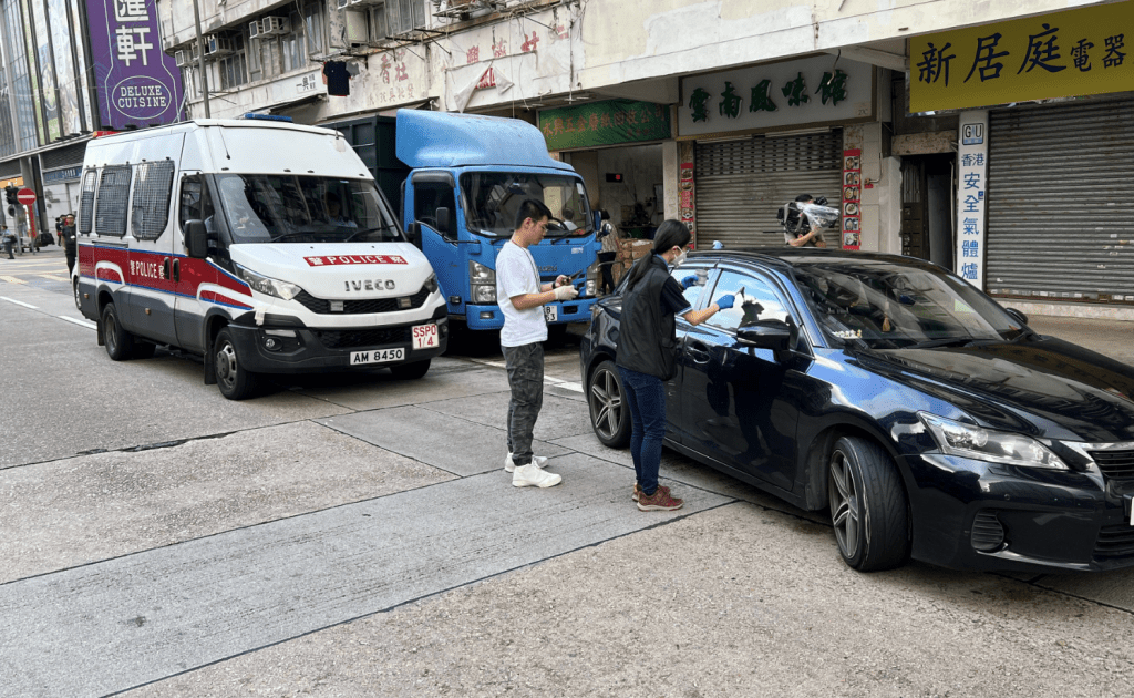警方懷疑一輛泊在順寧道的深色私家車與事件有關,在現場進行搜及「掃指模」。黎志偉攝 警方懷疑一輛泊在順寧道的深色私家車與事件有關,在現場進行搜及「掃指模」。黎志偉攝