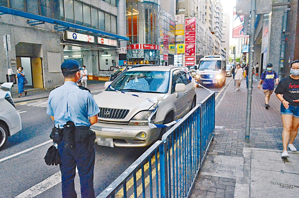 三匪棄車挾款逃去，警方在賊車旁調查。