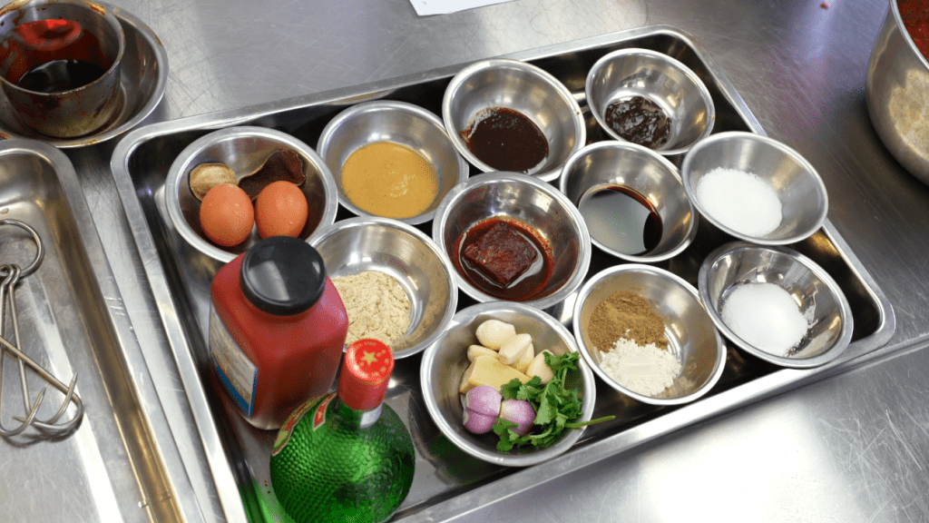 腌制叉烧所须的调味料有十多种，师傅会派发笔记让学生跟著调制。