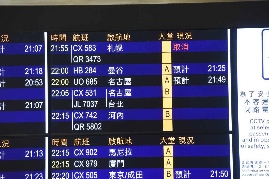 機場接機大堂顯示屏註明札幌開出的CX583航班已取消。尹敬堂攝
