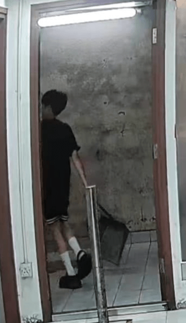 年輕男生將後樓梯清潔工的垃圾鏟扔走。（受訪者提供）