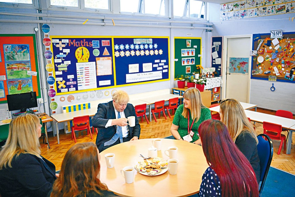英國教師將獲加薪百分五。圖為首相約翰遜與幼兒園教師茶敍。
