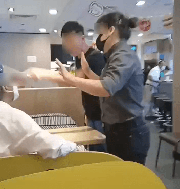 影片開頭見到一名黑衣中年漢（中），站起怒斥一名白衫婆婆（左），婆婆帶有面罩及口罩，快餐店店員（右）正在居中調停。
