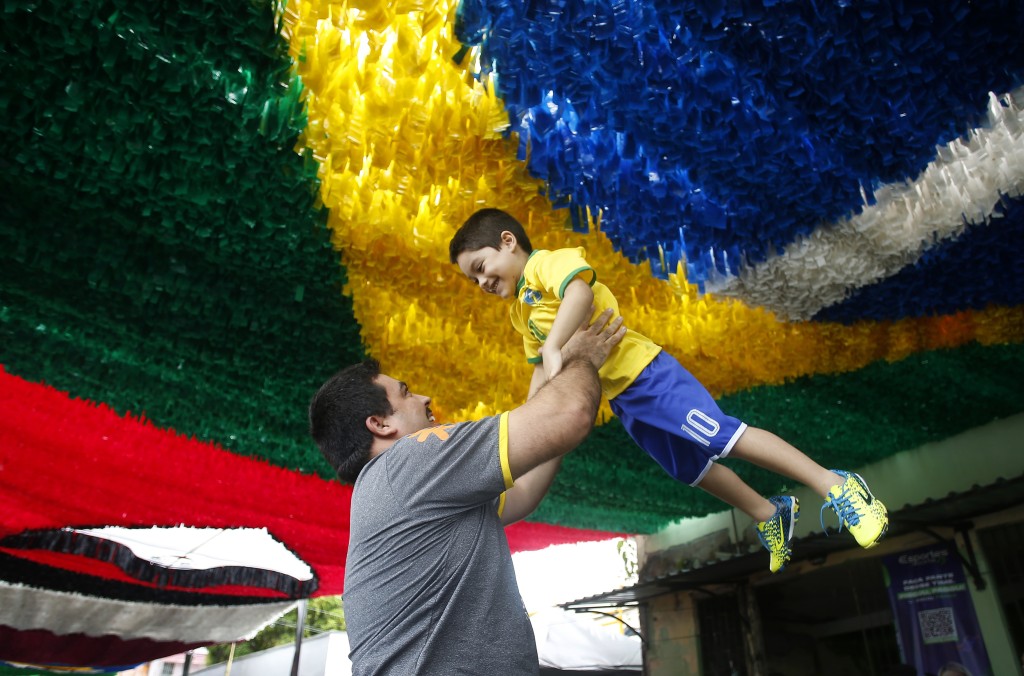 巴西父親抱起兒子慶祝。 AP