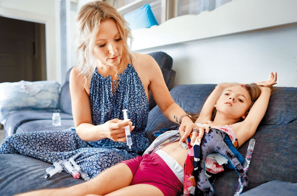 美國十一歲女童阿吉拉爾患極罕見基因疾病，只能吃特殊配方奶粉，其母現只剩一星期存貨。圖為她替女兒注射藥物。