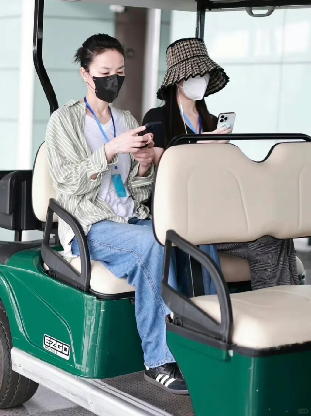 王菲與李嫣登上高爾夫球車時，各自各睇電話。