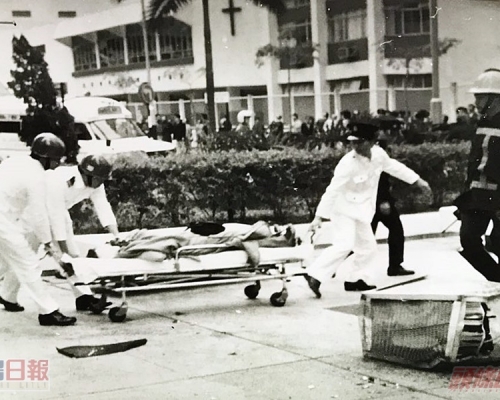 救護員搶救一名女途人,惜已返魂乏術。前右是飛墮下來的冷氣機。資料圖片