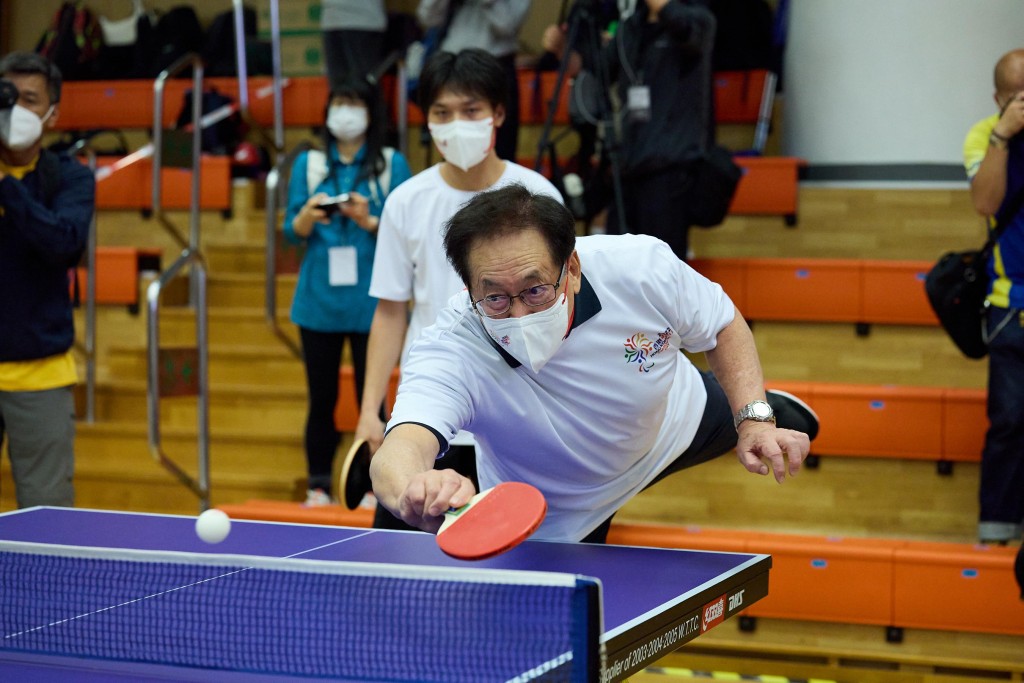 香港殘疾人奧委會名譽會長周一嶽和香港智障運動員范家華於活動會場組隊切磋乒乓球球技。公關提供圖片