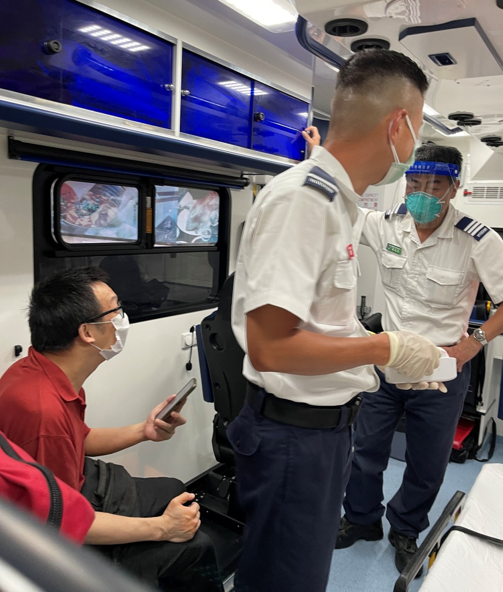 男途人(紅衫者)在救護車上接受治理。