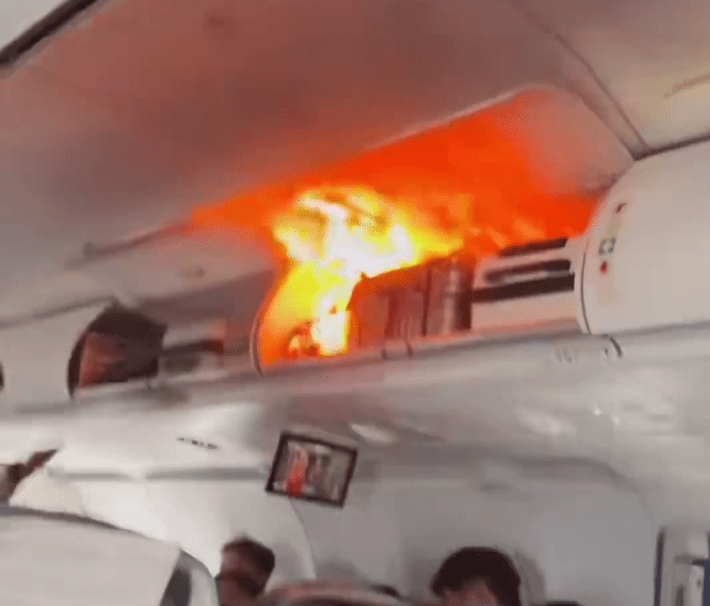 飛機客艙行李架上出現了明火。 飛機客艙行李架上出現了明火。