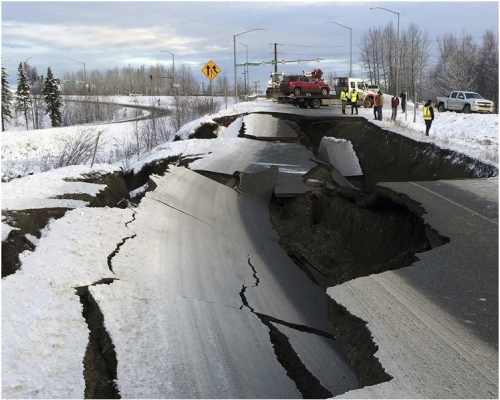 地震後道路出現路陷,有汽車被困。。AP