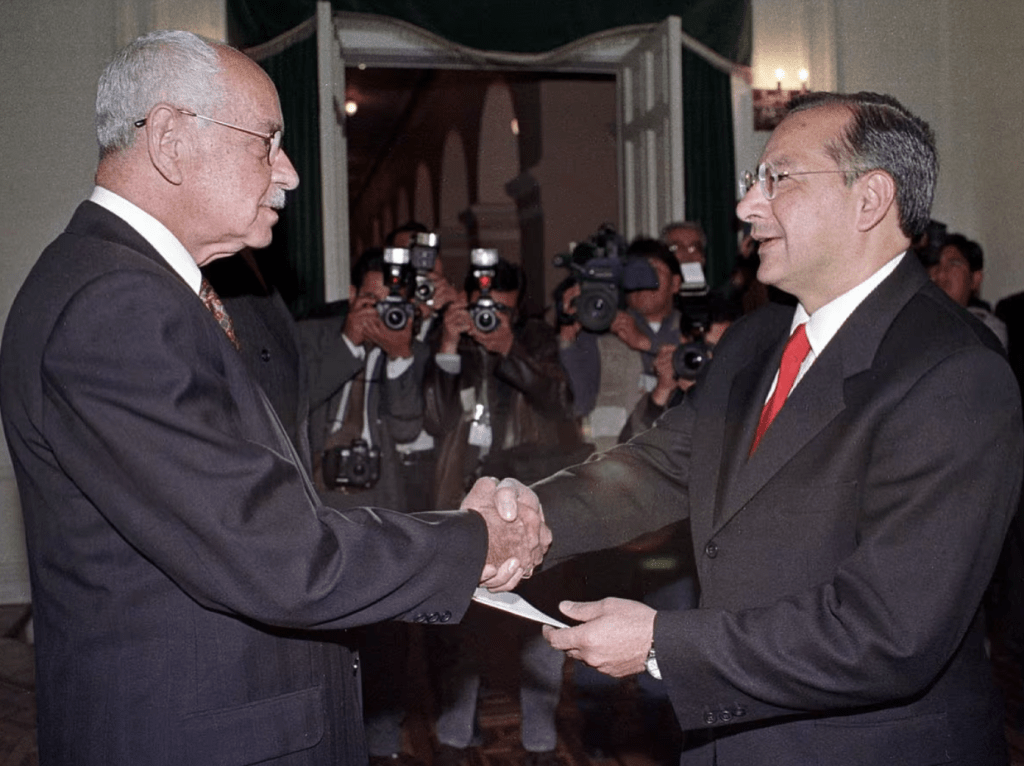 2000年8月3日，时任美国驻玻利维亚大使罗查(左)在拉巴斯政府宫与玻利维亚总统雨果·班泽(Hugo Banzer) 握手。路透社