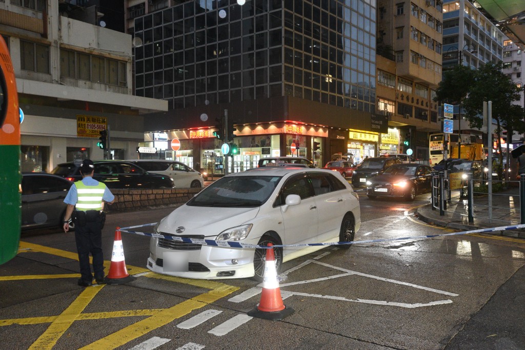 涉事白色私家車入黑後仍被圍封調查，警方在場維持交通。(尹敬堂攝)