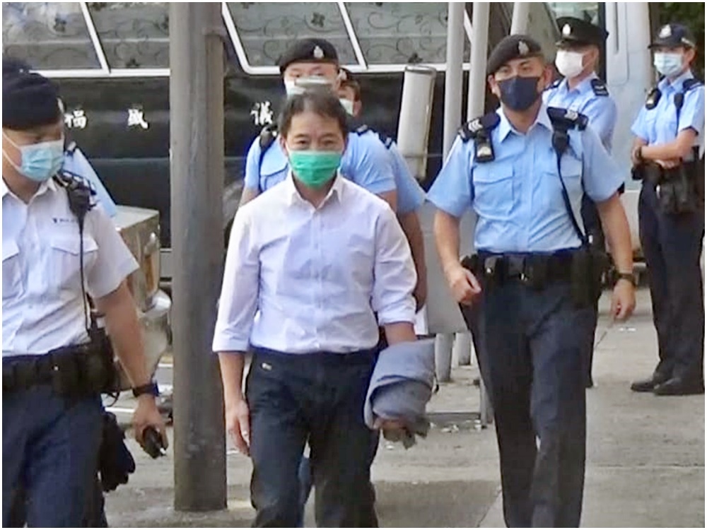胡志偉由警方陪同下前往殯儀館。