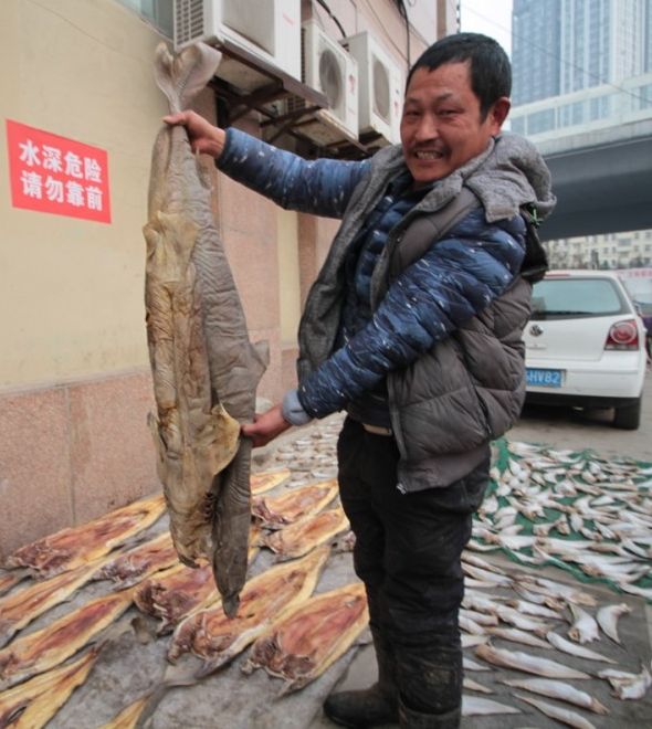 商贩在展示晒成干的鲨鱼干。