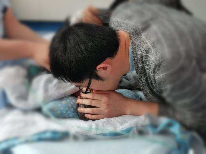 進手術室前,爸爸親吻小毛豆。網上圖片