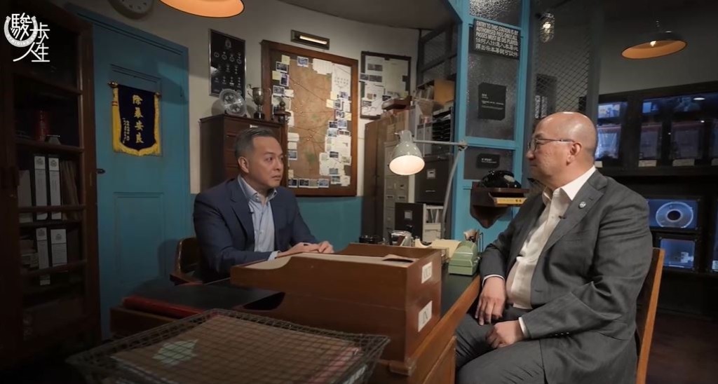 警務處處長周一鳴（左）在訪問中，與馬會公司事務執行總監譚志源對談。《駿步人生》影片截圖