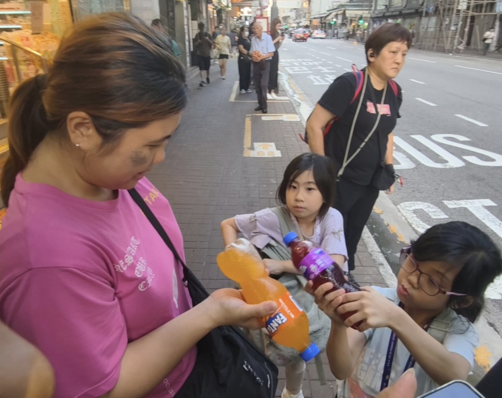 蘇先生一家的小朋友即場檢查手上汽水。