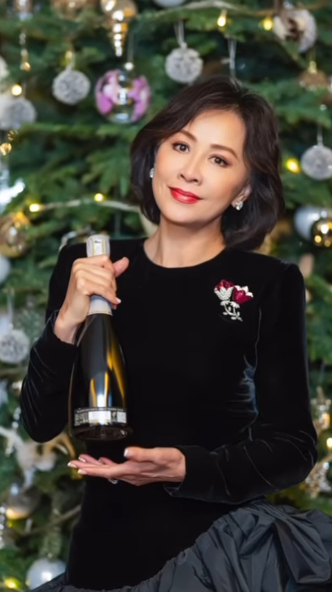 劉嘉玲拿美酒於聖誕樹前留影。
