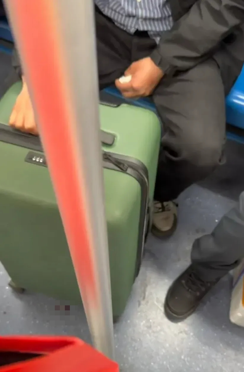 男子携带的是一个绿色箱子，手里还拿著纸巾，疑似在擦拭血渍。