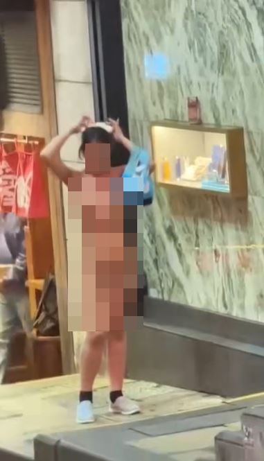 女子一絲不掛，但無視途人目光。網上影片截圖