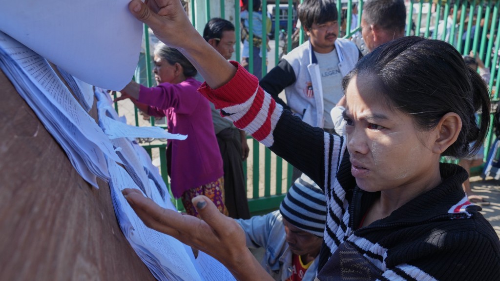 缅甸大选|选民在票站外的登记册寻找自己的名字。 美联社 缅甸大选|选民在票站外的登记册寻找自己的名字。 美联社