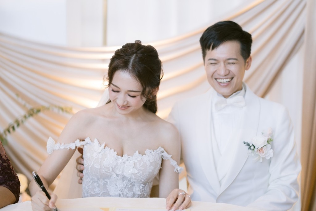 曾曉婷與老公簽紙。 曾曉婷與老公簽紙。