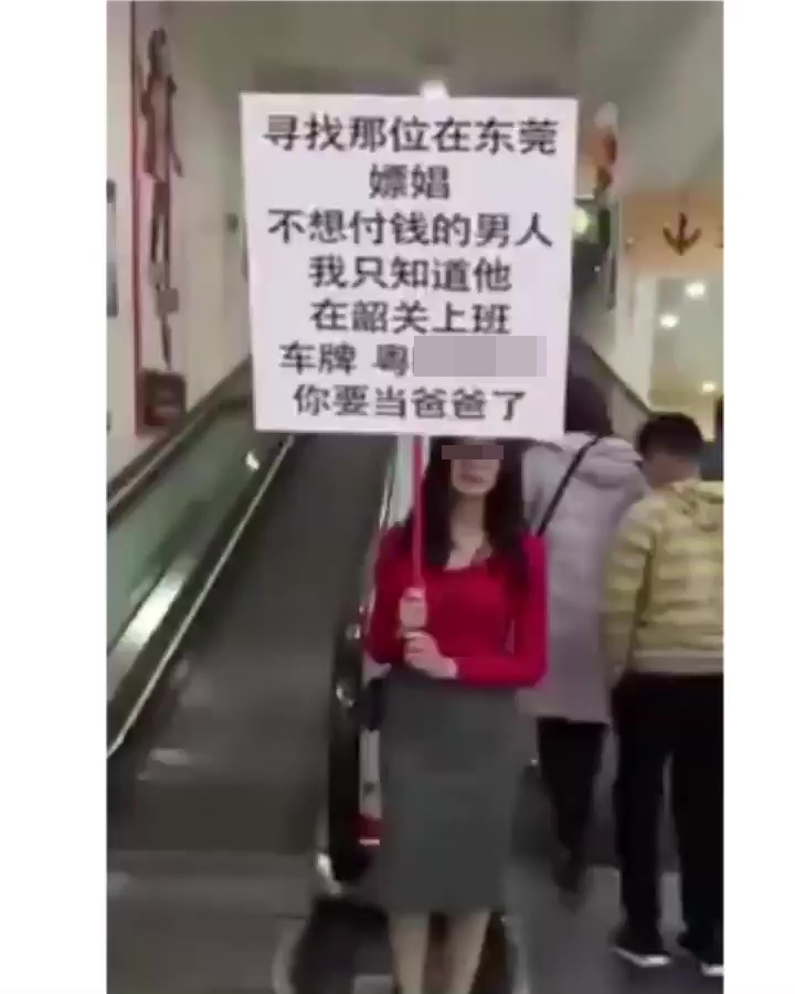 一名打扮斯文的女子，在人來人往的電梯口舉牌尋人。網上截圖